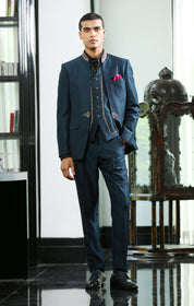 A teal embroidered suit with cravat, designer wear.
