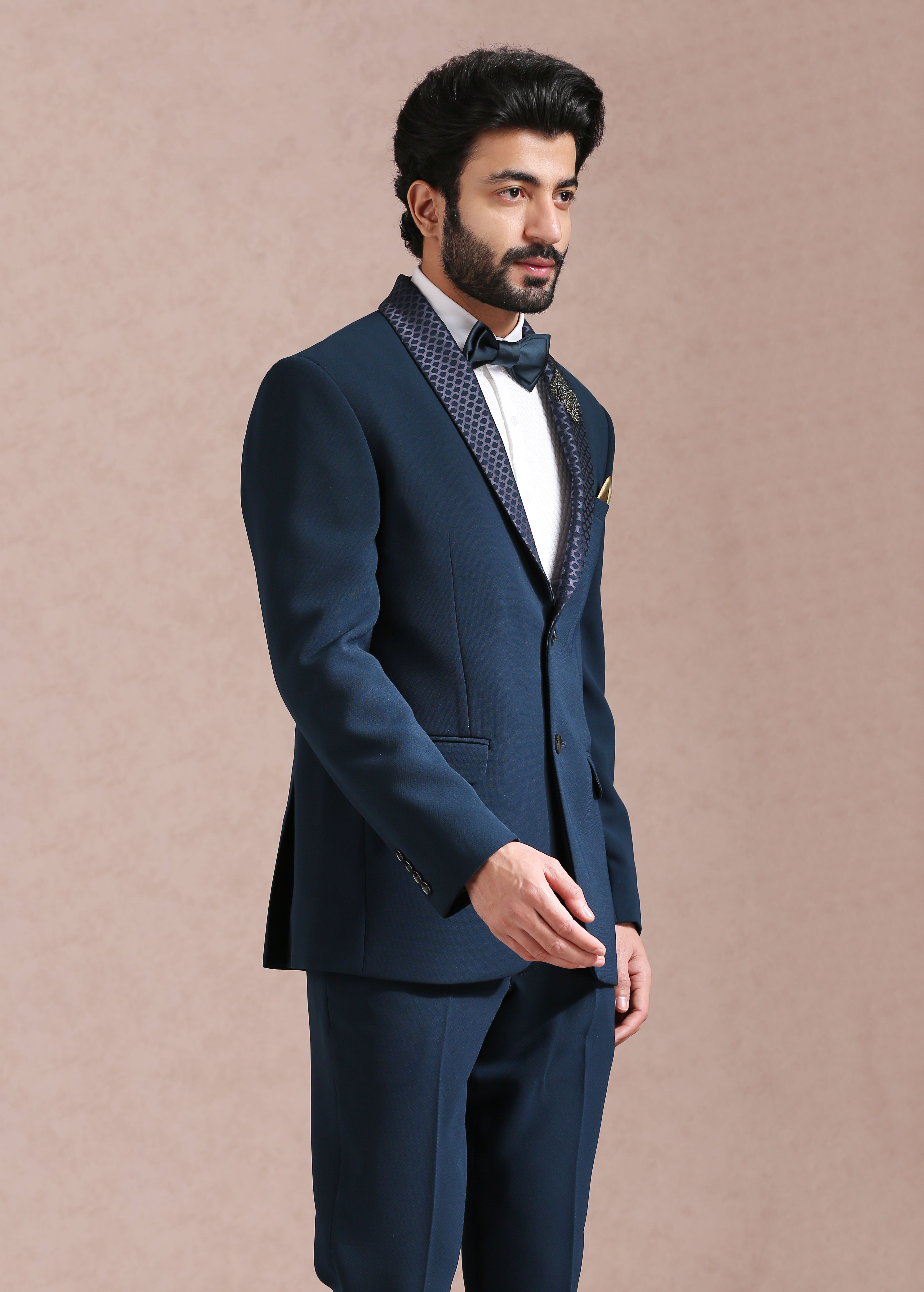 A timeless teal suit with embroidered motif.


